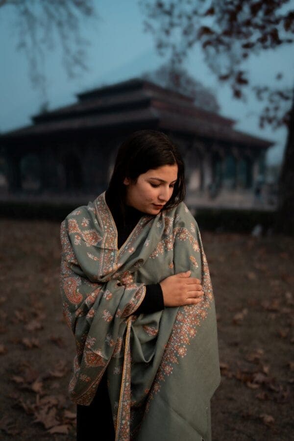 Woman wrapped in a sage pashmina shawl at dusk